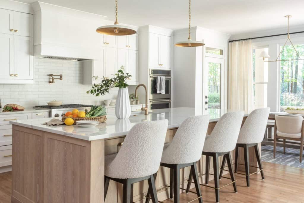 Kitchen with wood island, counter height stools, and pendant lighting.