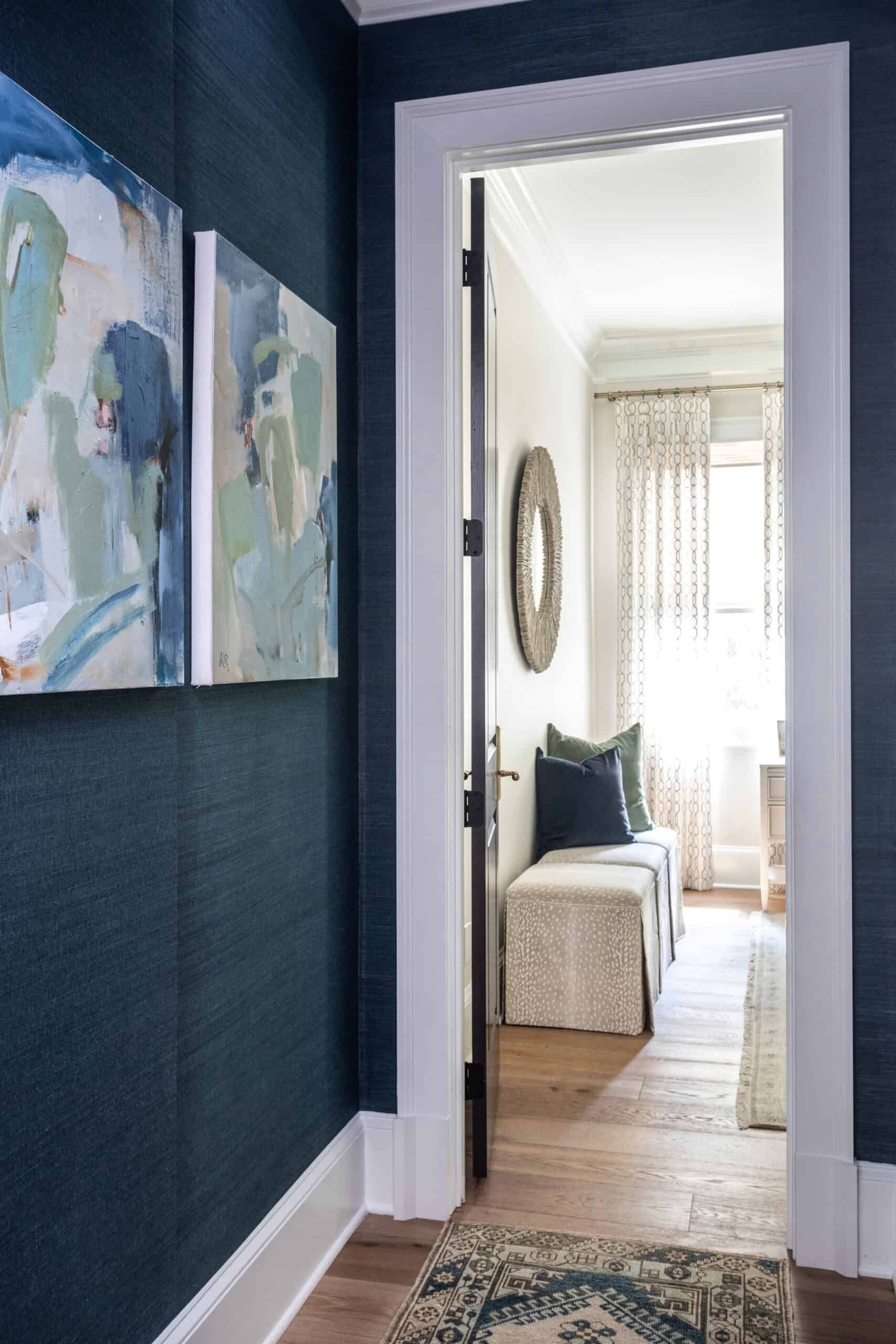 Hallway with blue grasscloth walls and blue abstract artwork.