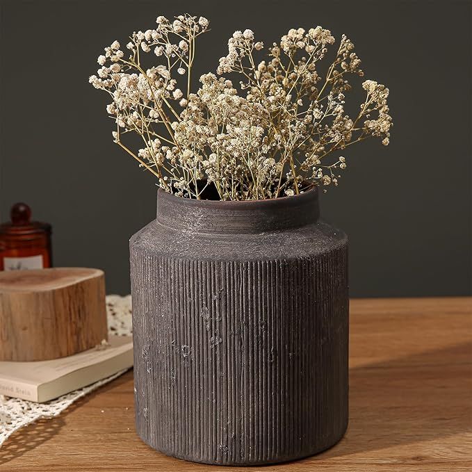 Rustic brown ribbed vase with dried white flowers. 