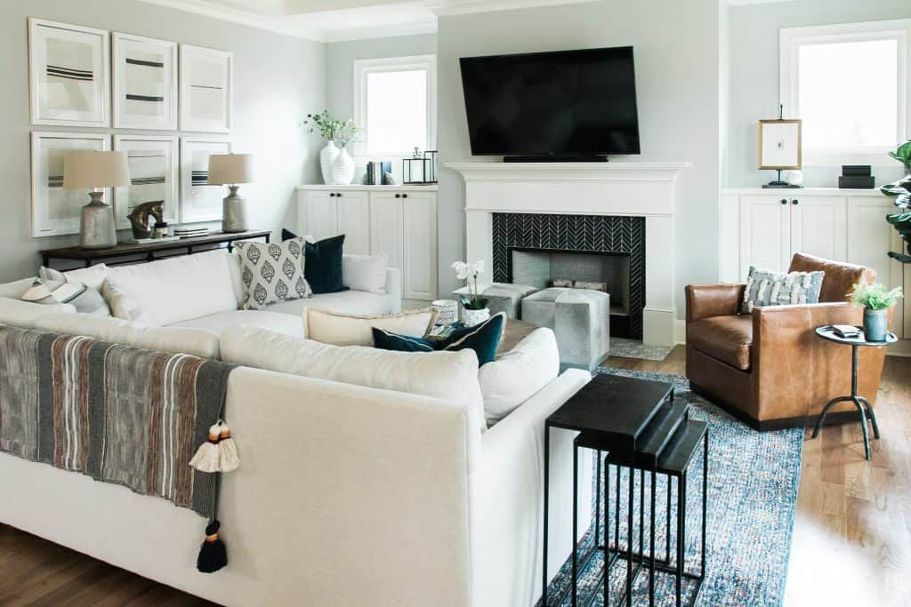 An image of the Briarwood Park living room with modern southern style couch, leather chair, brass decor, and classic design elements.
