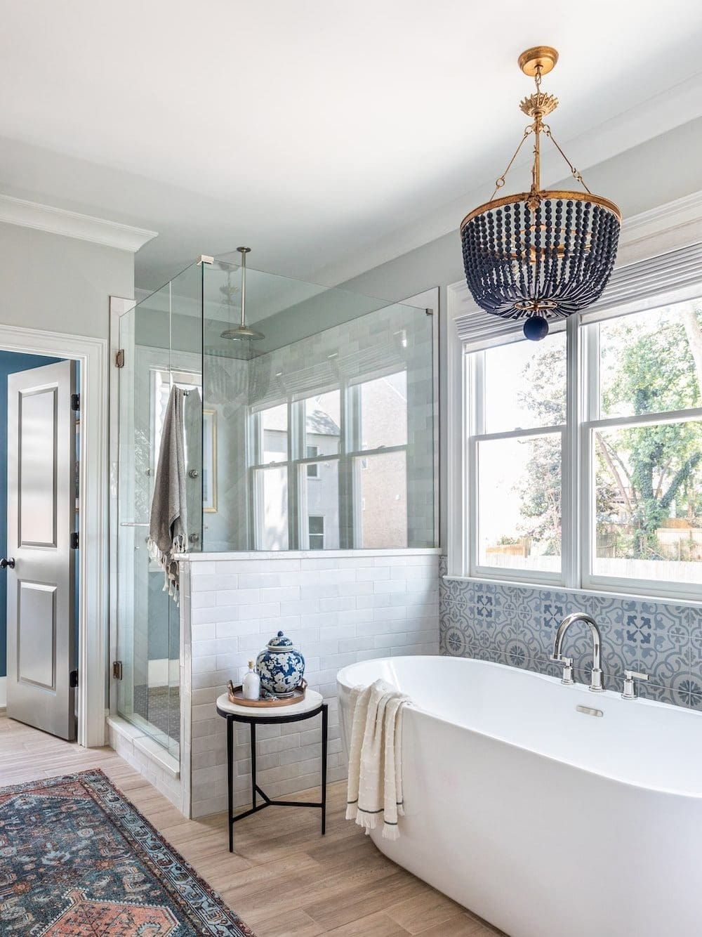 Image of a modern southern style Georgia bathroom, complete with blue chandelier and blue patterned wall tile.