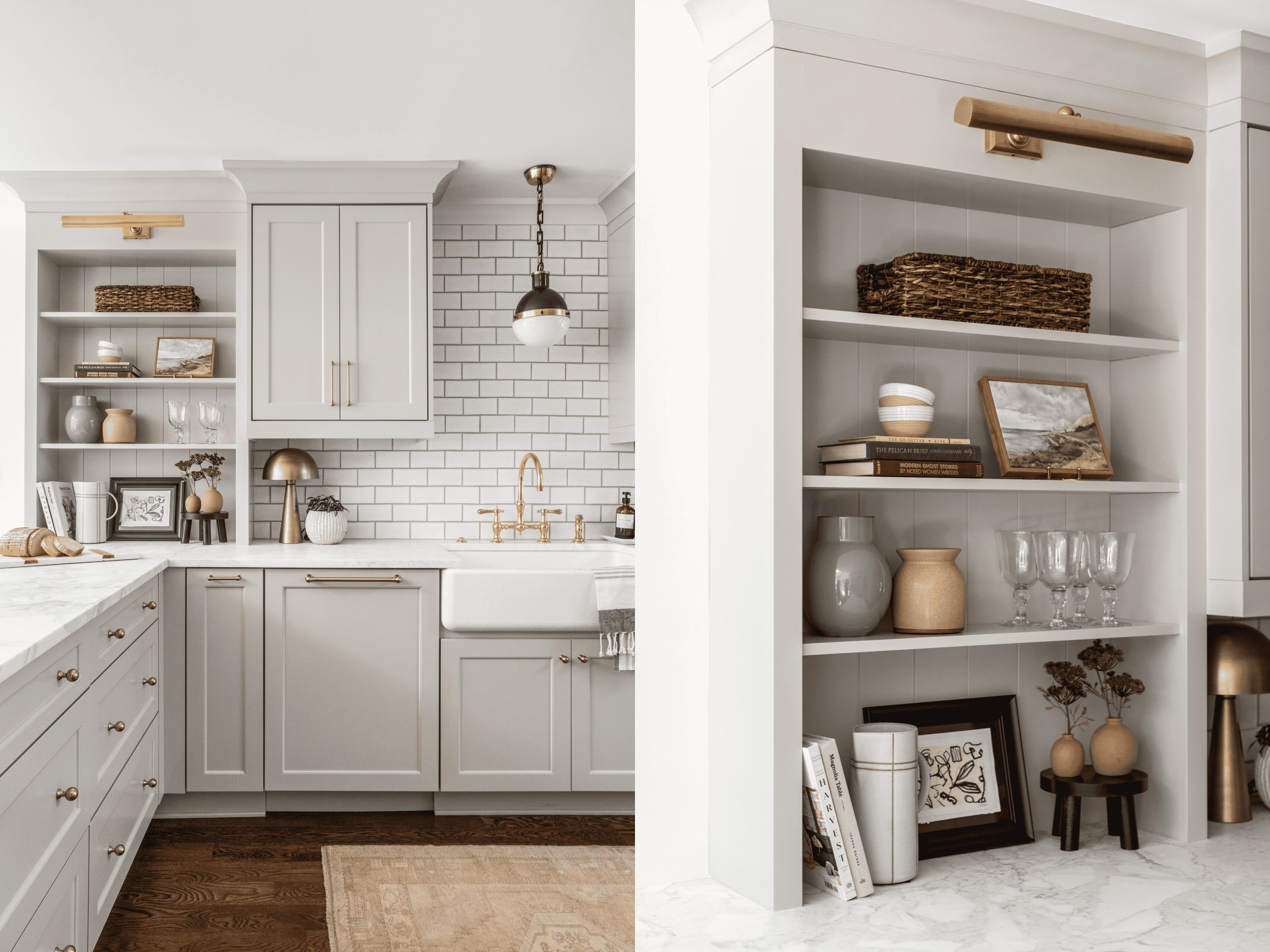 Black and white pendant light hanging over kitchen sink, next to a shelving area with ceramics, glasses, and art that is illuminated by an unlaquered brass shelving light. 