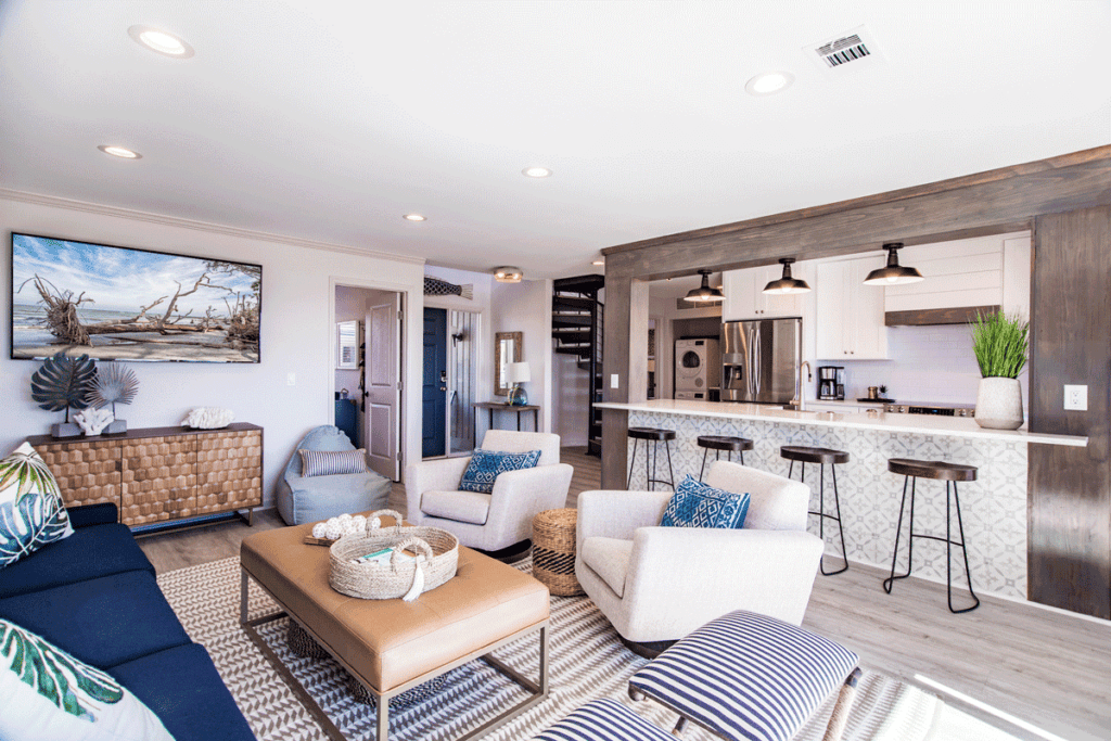 frip island living room with navy blue couch, tan upholstered coffee table and white comfy chairs.
