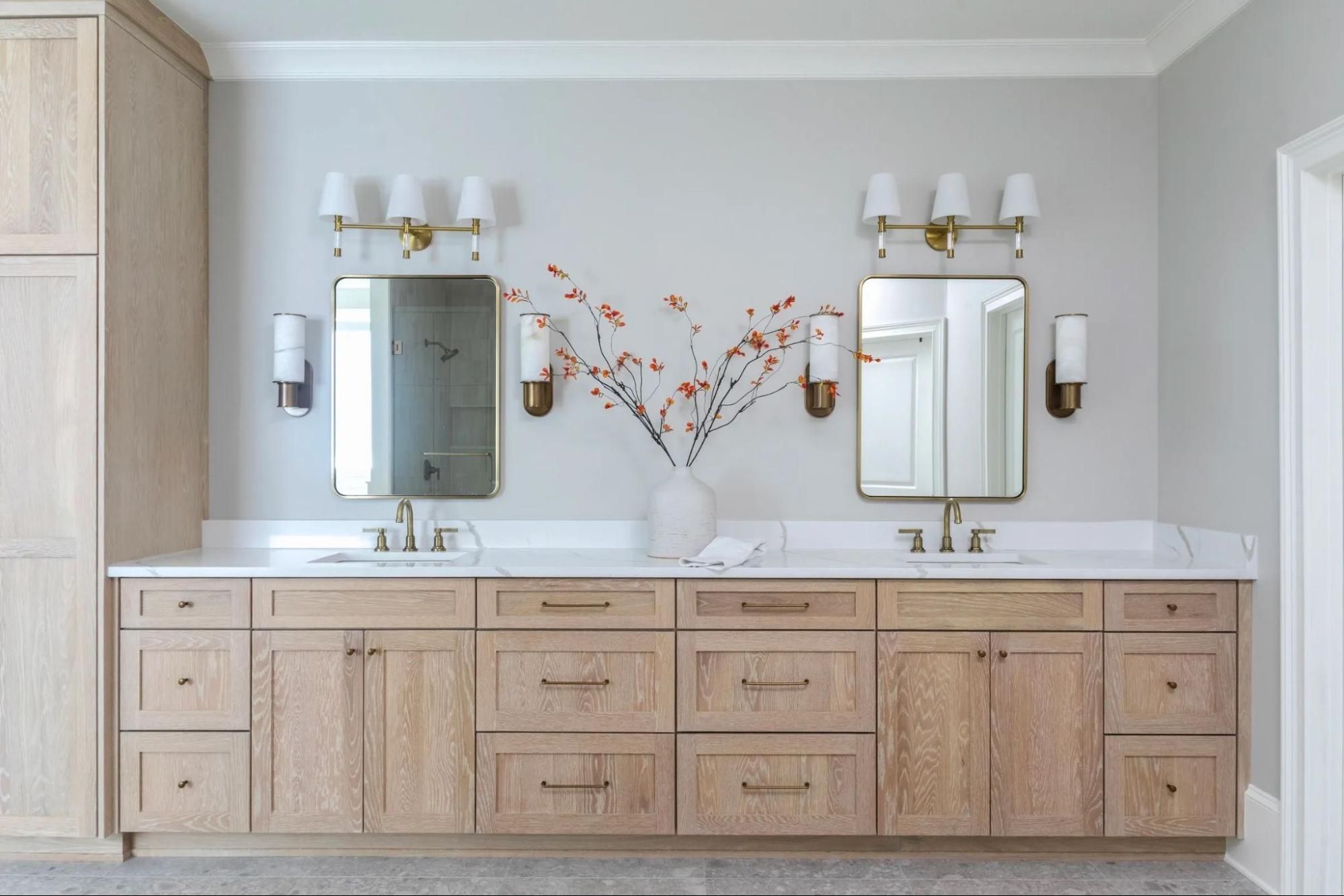 Bathroom with natural wood cabinets, lampshade lighting, and gray walls.