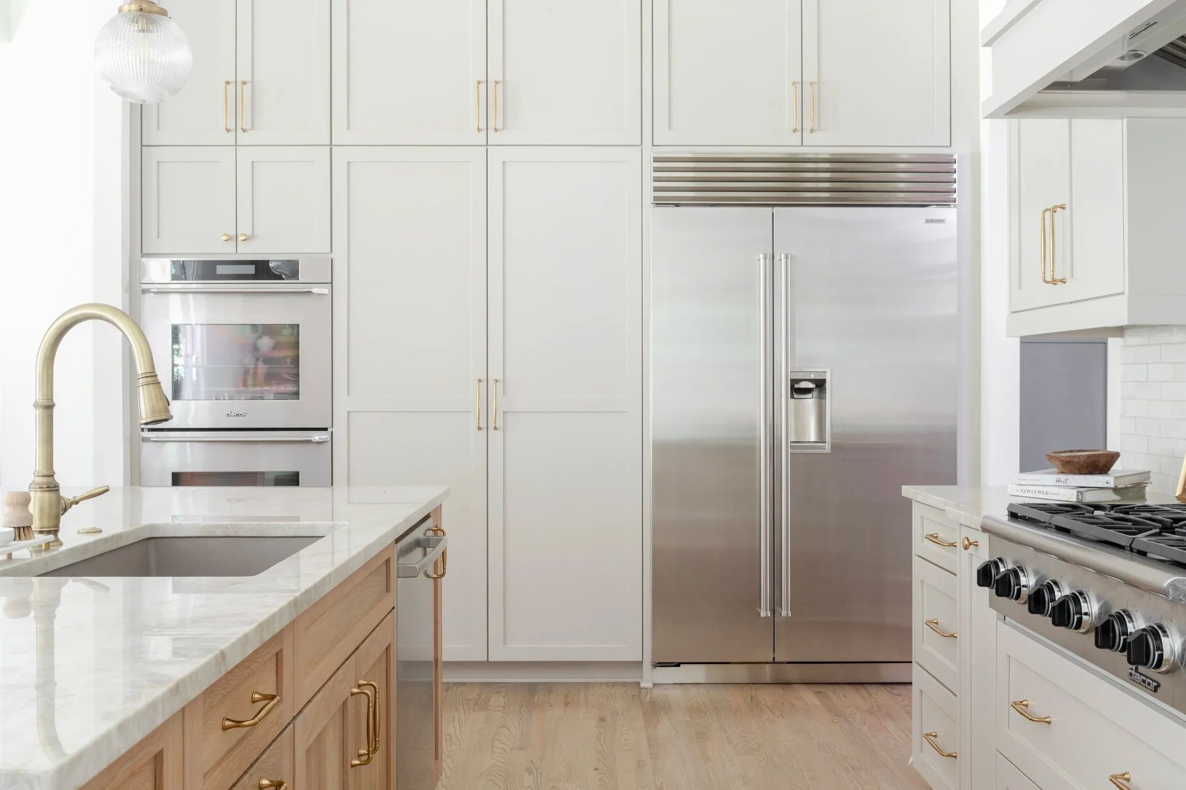 Kitchen with white cabinets, metal hardware, and light wood flooring.